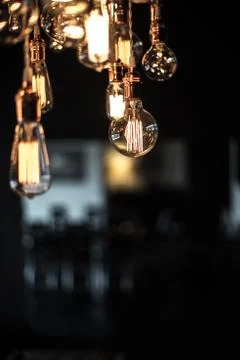 Hanging array of many incandescent light bulbs Stock Photos