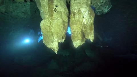 Hanging cave formations silhouetted against blue underwater light Stockbeeldmateriaal 341378438