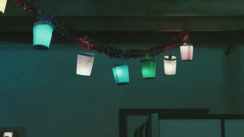 Hanging colored lantern lights inside rustic interior Stockbeeldmateriaal 325363708