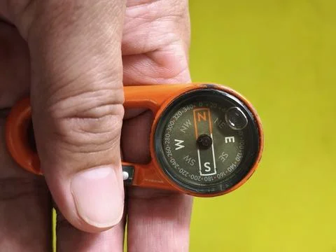 A hanging compass in hand Stock Photos