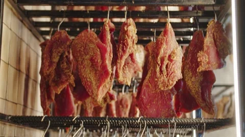 Hanging cured meats on racks in a drying facility Stock Footage 301527027