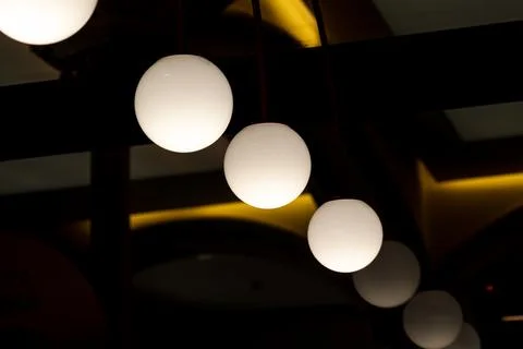 Hanging globe lights in dark interior Stock Photos