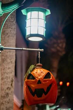 Hanging Jack-O’-Lantern Under Outdoor Lamp at Night Stock Photos