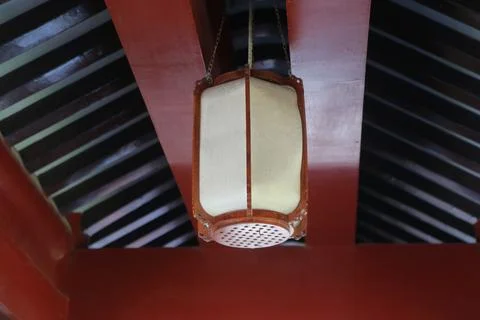 A hanging lantern with an open square white felt cover and red leather edge.. Foto stock