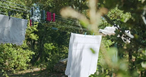 Hanging Laundry Wet Bed Sheets On Clothesline in Countryside in summer day. Stock Footage 202512484