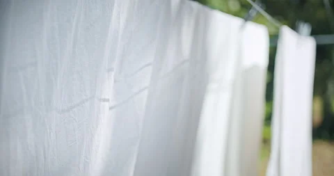 Hanging Laundry Wet Sheets On Clothesline in Countryside in summer day. Video stock 202502793