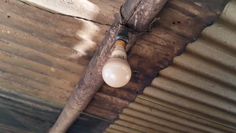 Hanging Light Bulb in Rustic Rural House Interior with Corrugated Metal Ceiling Stock Footage 335149291