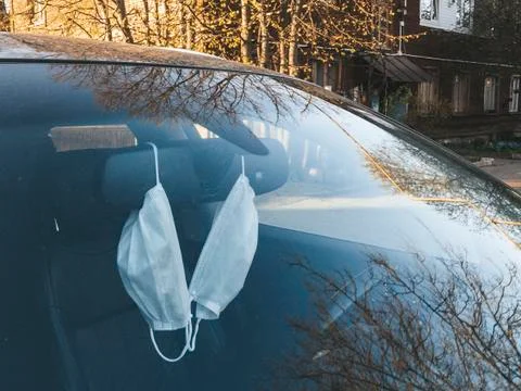 Hanging masks in a car behind a windshield Stock Photos