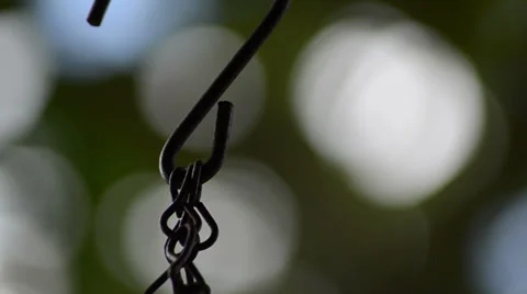 Hanging metal string with unfocused green background Video stock 34636637