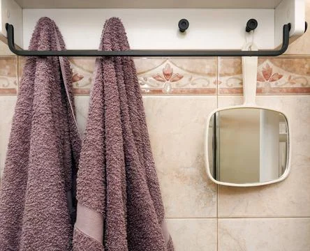  hanging objects in the bathroom: two towels and a white mirror hanging ob... Stock Photos