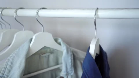 Hanging on Rack Hand With is Choosing T-shirt Tacking off Hang from Bar Stock Footage 148126829