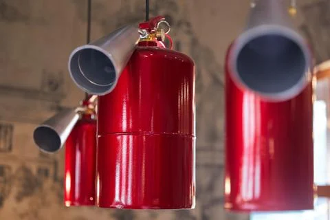 Hanging red fire extinguishers on the ceiling Stock Photos
