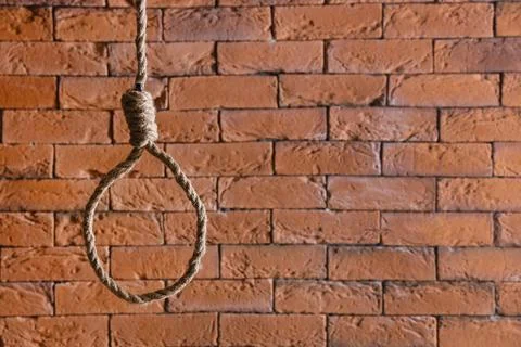 Hanging rope with loop on brick background. Suicide concept Stock Photos