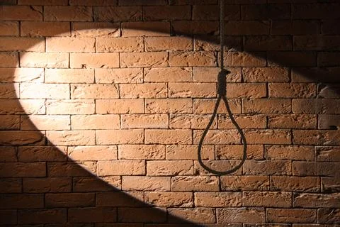 Hanging rope with loop on dark brick background. Suicide concept Stock Photos