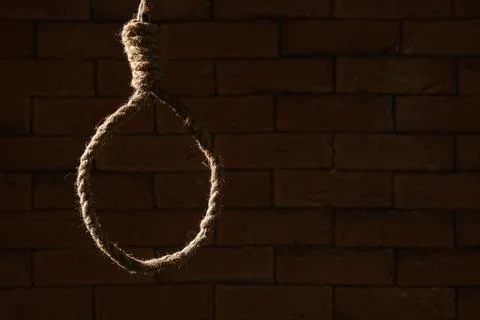Hanging rope with loop on dark brick background. Suicide concept Stock Photos