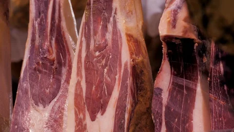 Hanging in a row jamon in the store. Traditional Mediterranean food. Close-up. Stock Footage 122768441