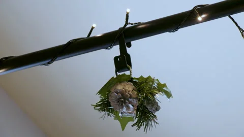 Hanging silver mistletoe, pine cone decoration with twinkle lights Stock Footage 295920549