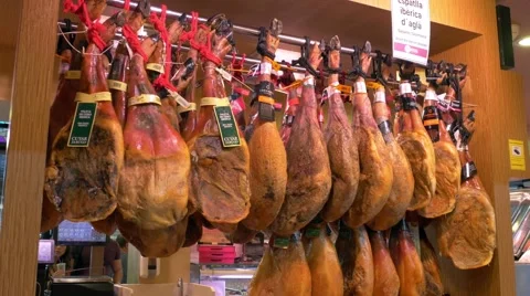 Hanging spanish ham in the market La Boqueria in Barcelona Stock Footage