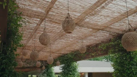 Hanging wicker lanterns under woven canopy in outdoor venue Stock Footage 328956897