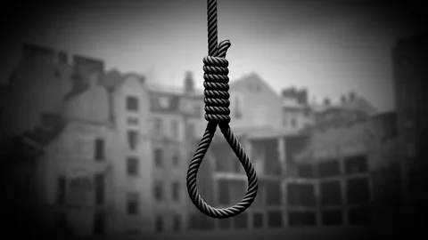 Hangman's noose against the backdrop of a war-torn city Stockbeeldmateriaal 112016858