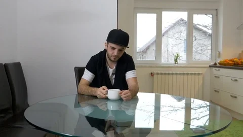 Hangover man in the kitchen trying to wake up while drinking coffee early i.. Stock Footage 72897203