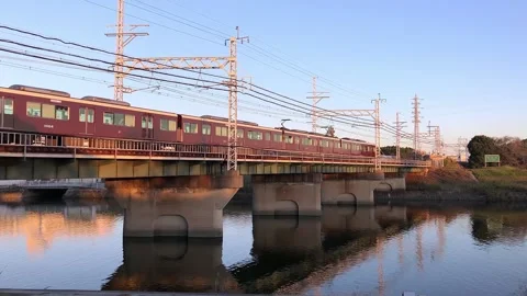 Hankyu train crossing a bridge over a river in Osaka, Japan. Stock Footage 143778719