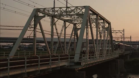 Hankyu train crossing a bridge at sunset near Osaka. Stock Footage 155469373