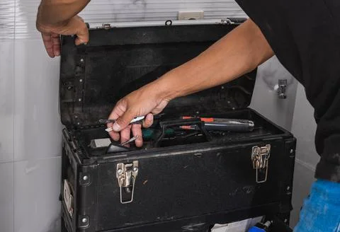 Hans of a man looking for tools in a toolbox Stock Photos