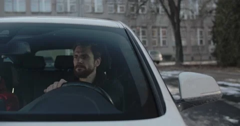 Hansome man looking for a parking place backing the car Stock Footage 170428709