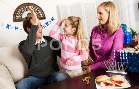 Hanukkah: girl high fives dad after winning Stock Photos