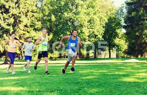 Happ young sportsmen racing wit badge numbers Stock Photos