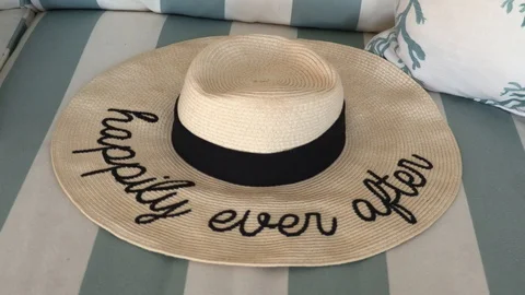 Happily Ever After Straw Hat Laying on a Striped Couch at a Beach House. Stock Footage 108711099