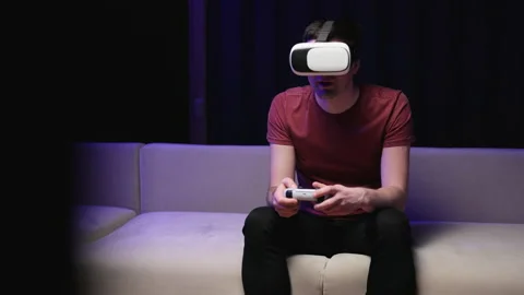 Happiness gamer playing game using VR glasses in living room. Caucasian man hold Stock Footage 194551436