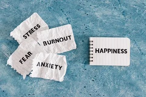 Happiness text on notepad surrounded by Fear Anxiety Stress and Burnout words Stock Photos