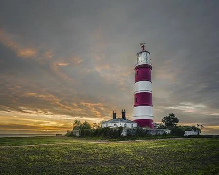Happisburgh Lighthouse at Dawn under a dramatic clouded sky Stock Photos