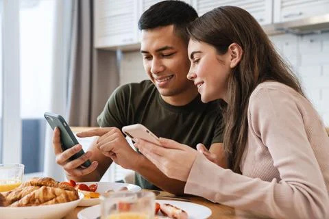 Happpy young attractive couple using mobile phones Stock Photos