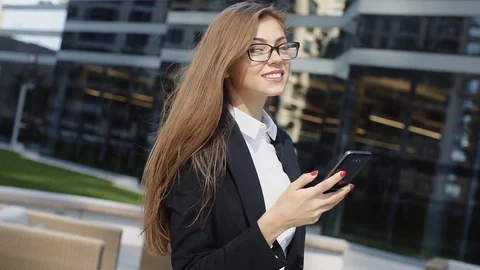 Happy 30s lady texting message on smartphone near office building Stock Footage 101082972