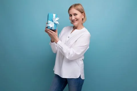 Happy 50s woman received surprise gift in box on studio background Stock Photos