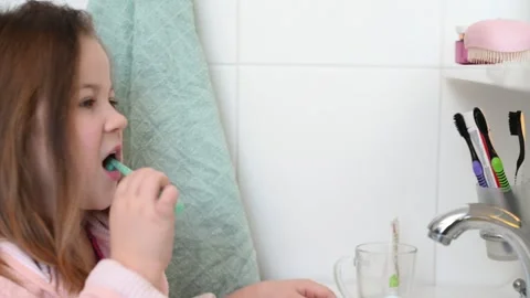 Happy 7 year old child brushes his teeth in the bathroom near the mirror  Stock Footage 271733986