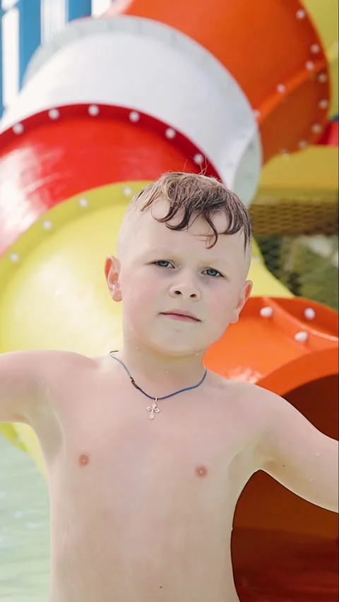 Happy 7 years old boy in water amusement park spends summer holidays Stock Footage 278421803