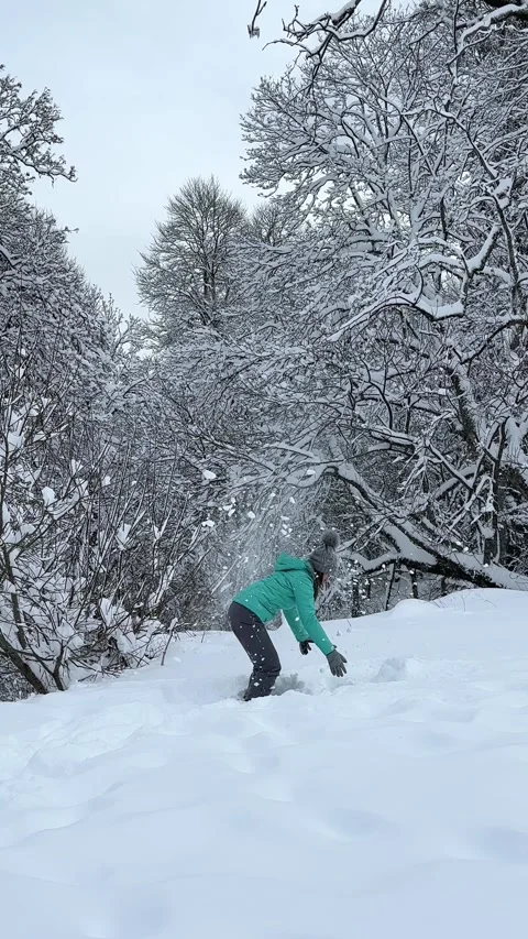 Happy active girl having fun and throwing snow in winter forest Stock Footage 252850977