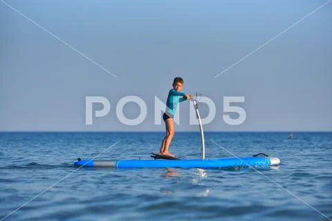 Happy active kid on a Hobie Stand Up Paddle board Stock Photos