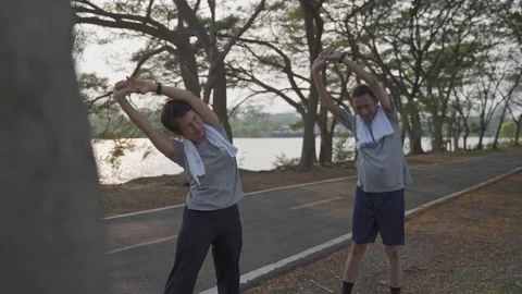 Happy active senior couple exercise and stretching at park in evening sunset. sm Vídeos de archivo 157978284