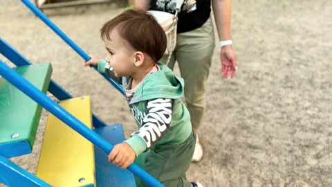 Happy active toddler going up by the stairs of the slide. Video stock 245320169