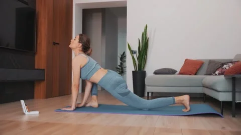 Happy active woman doing warm-up, gymnastics sports training at home living room Stock Footage 311831907