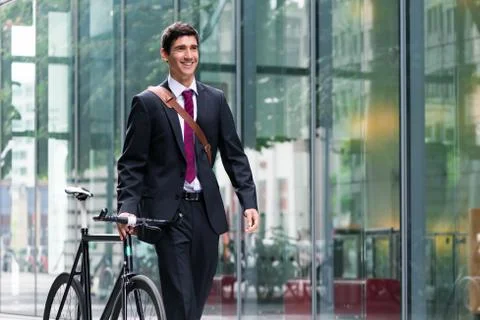 Happy active young man walking to the job after bicycle commutin Fotos de archivo