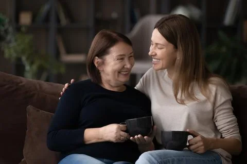 Happy adult daughter and mature mother relax at home Stock Photos