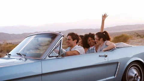 Happy adult friends on a road trip in convertible, close up Stock Footage