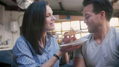 Happy affectionate young couple taking rest and eating sweets in loft living Stock Footage 105759203