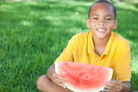 Happy african american boy child eating water melon Stock Photos